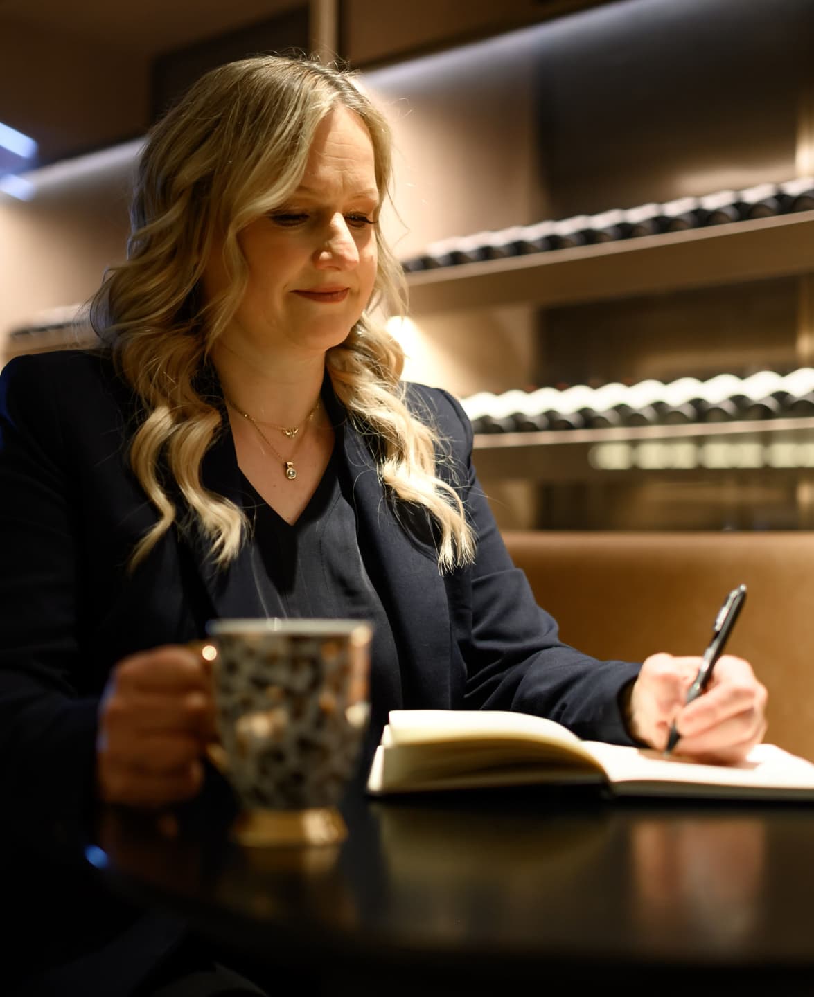 Nina Christian sitting at a table, writing notes by hand